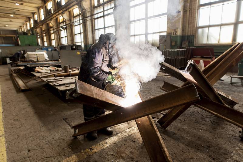 A worker welds metal inside the Interpipe Steel plant in Dnipro, Ukraine. Exports of steel gas pipes to Texas oil companies and railway wheels to European high-speed train operators has been put on hold as hundreds of the company’s 10,000 employees in the country have joined the fight against Russia. Working with a skeleton crew, Interpipe facilities are running canteens and making metal barriers to block Russian tanks and convoys. At night, its bomb shelters house dozens of local families. AP