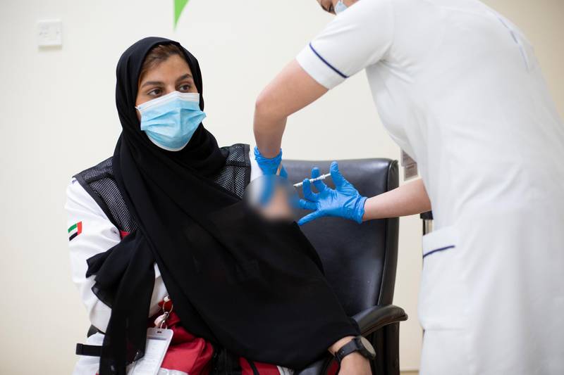 Shamaa Saif Rashid Alalili, 36, a Dubai Ambulance worker, receives the Covid-19 jab