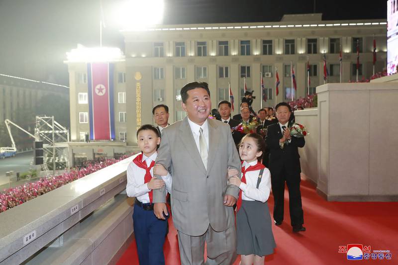 North Korean leader Kim Jong-un with two young "fans".  AP