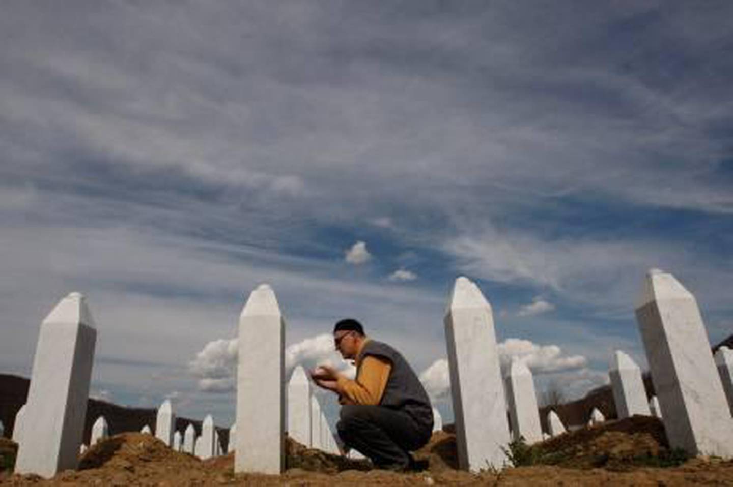 Bosnian Muslim man says a prayer in front of the grave stone of his relative at Memorial Center of Potocari, near Srebrenica, 70 kms norteast of Bosnian capital of Sarajevo, on Thursday April 1, 2010.  Serbia's parliament has apologized to the Bosnian Muslim victims of the 1995 Srebrenica massacre Wednesday, ending years of denial, a move which is being seen as a crucial part for reconciliation in the war-scarred Balkans. (AP Photo/Amel Emric) *** Local Caption ***  XAE107_BOSNIA_SREBRENICA_SRBIJA_APOLOGIZE.jpg
