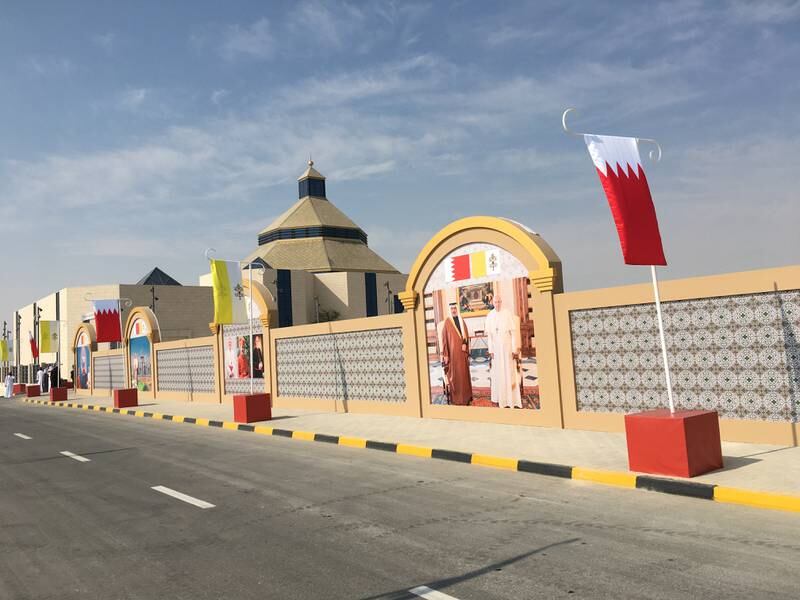 The streets outside Our Lady of Arabia cathedral are festooned with the Bahraini and Papal flags. John Dennehy / The National