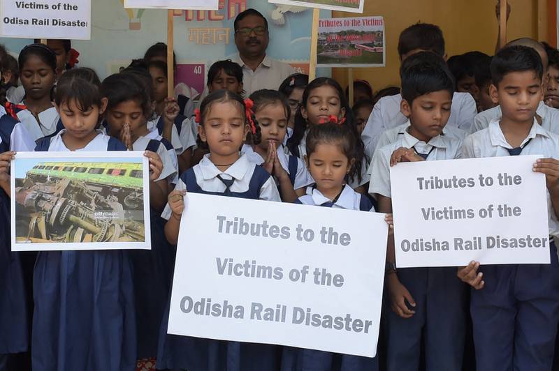 Children hold placards as they offer prayers for the victims and survivors of the three-train collision in India's Odisha state. AFP