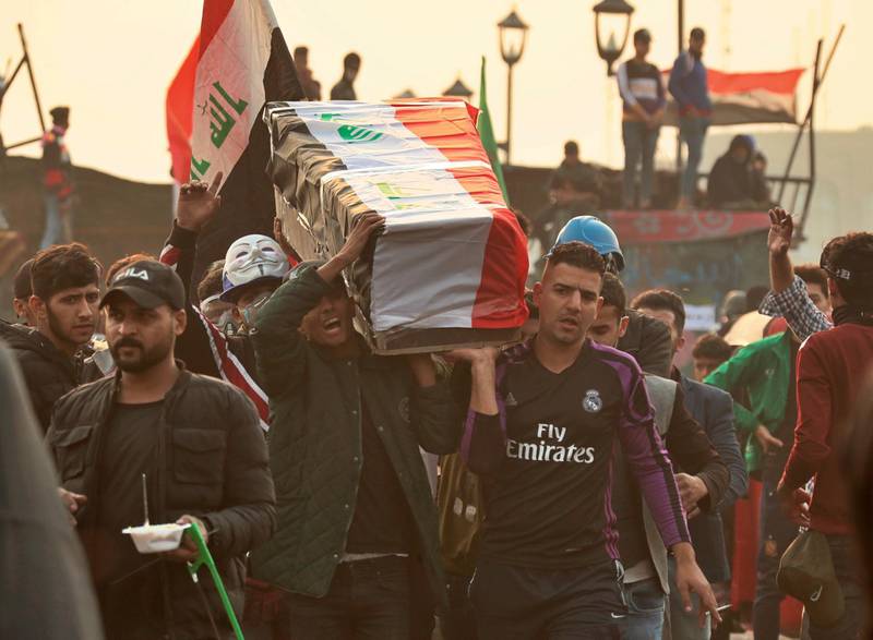 Anti-government protesters carry a symbolic coffin during ongoing protests in Baghdad. AP Photo