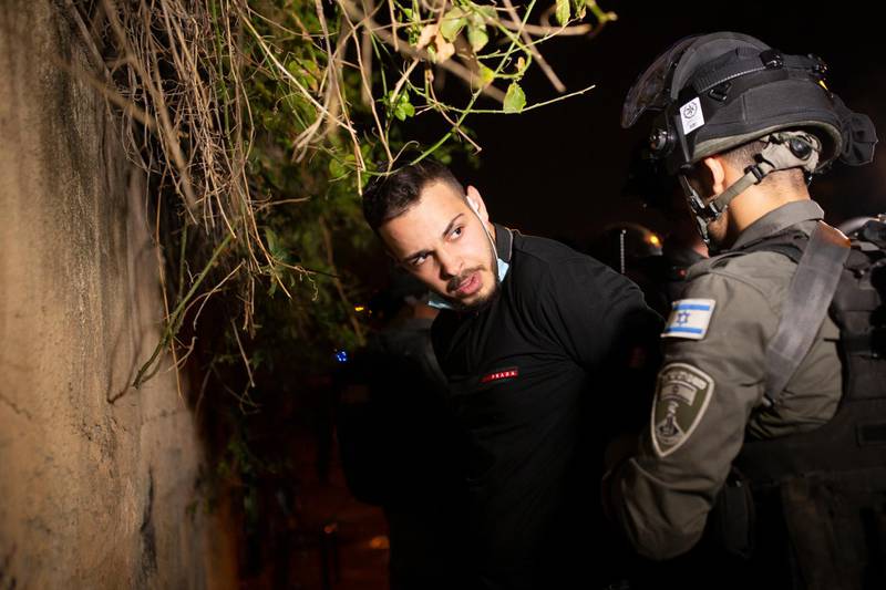 A Palestinian man is detained by Israeli police at a protest against the eviction of families from their homes in Sheikh Jarrah, East Jerusalem. Protesters and Jewish settlers hurled rocks and chairs at one another. AP