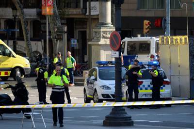 Medical staff members and policemen stand in a cordoned-off area. Josep LAGO / AFP.