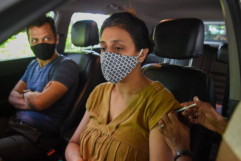 A woman gets inoculated with a dose of the Covishield vaccine against the Covid-19 coronavirus at a drive-in vaccination facility in Mumbai on June 26, 2021. / AFP / Punit PARANJPE
