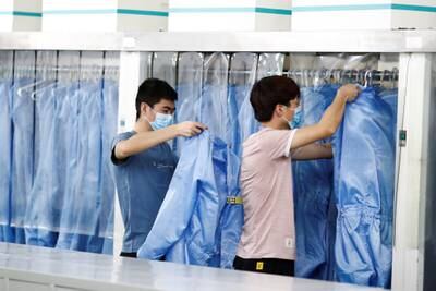 Employees change out their Personal Protective Equipment (PPE) before their lunch break at a factory of Renesas Semiconductor Co. during a government organised tour of the facility following the outbreak of the coronavirus disease (COVID-19), in Beijing, China May 14, 2020. REUTERS/Thomas Peter