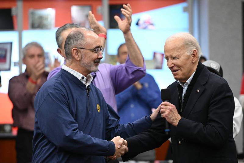 US President Joe Biden shakes hands with United Auto Workers president Shawn Fain during his brief visit to Michigan. AFP