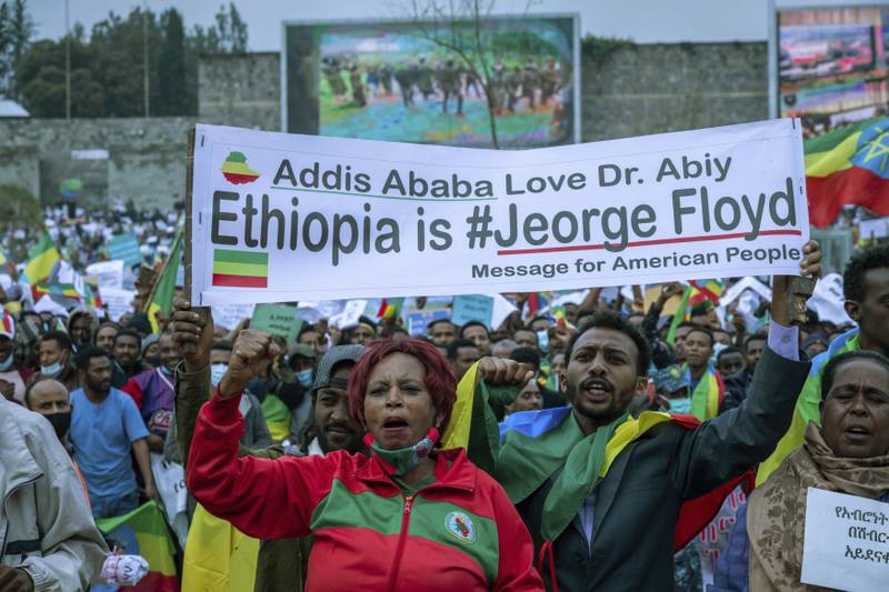 Residents of Addis Ababa wave Ethiopia's national flag and banner during a demonstration to protest against  the Tigray People's Liberation Front and to show their support for the Ethiopian national defence force, in the Ethiopian capital. The United Nations is trying to deliver aid to the country’s embattled Tigray region, which faces the world’s worst famine crisis in a decade with about 5. 2 million people in urgent need of help.