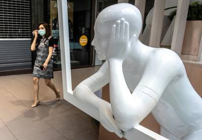 A woman enters a shopping mall partially closed to combat the spread of coronavirus, in Bangkok.  AFP