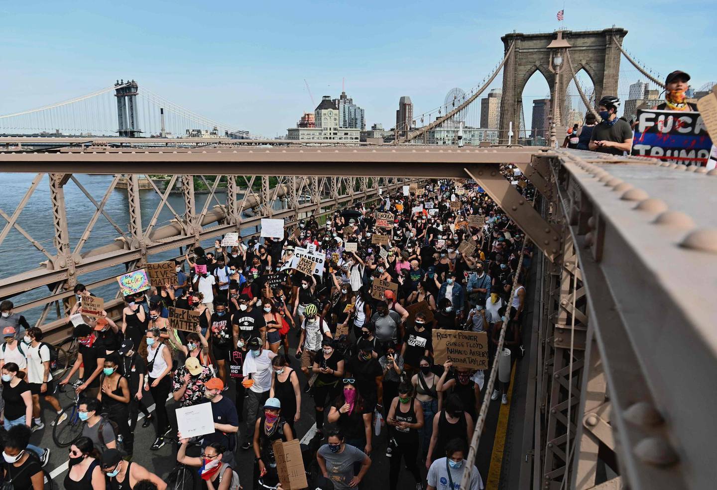 TOPSHOT - Thousands of protesters march over the Brooklyn Bridge to demonstrate against the death of George Floyd on June 4, 2020 in New York. On May 25, 2020, Floyd, a 46-year-old black man suspected of passing a counterfeit $20 bill, died in Minneapolis after Derek Chauvin, a white police officer, pressed his knee to Floyd's neck for almost nine minutes. / AFP / Angela Weiss
