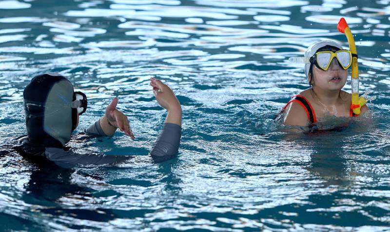 Iraqi female swimming coach Elaf, 35, teaches a child how to swim and dive, at a swimming pool in Basra. Reuters