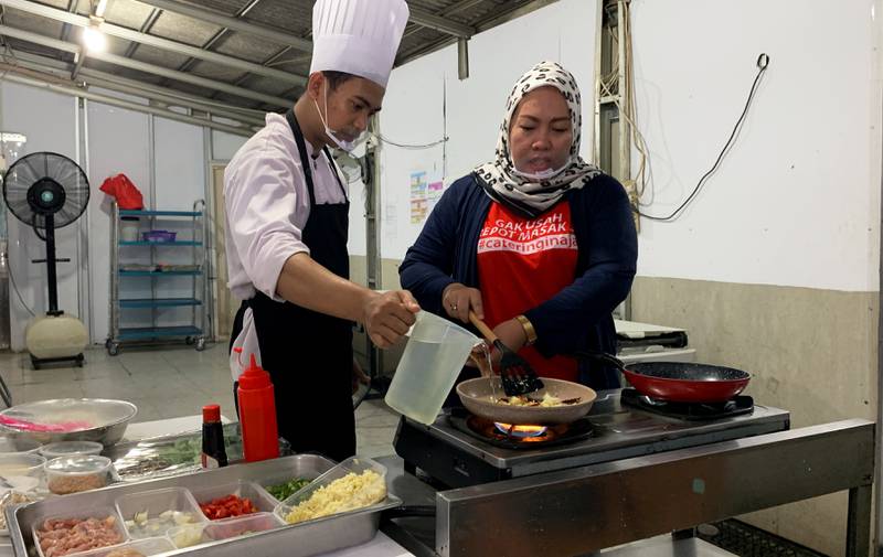 Catering company head Teni Daud, 37, prepares food with a colleague in Jakarta, Indonesia. Reuters