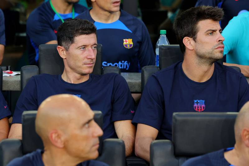 Robert Lewandowski and Gerard Pique of Barcelona look on from the bench during the friendly against Inter Miami. AFP