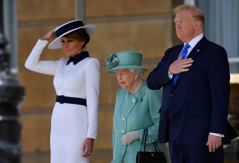 Britain's Queen Elizabeth II (C) stands with US President Donald Trump (R) and US First Lady Melania Trump (L) as they listen to the US national anthem during a welcome ceremony at Buckingham Palace in central London on June 3, 2019, on the first day of the US president and First Lady's three-day State Visit to the UK. Britain rolled out the red carpet for US President Donald Trump on June 3 as he arrived in Britain for a state visit already overshadowed by his outspoken remarks on Brexit. / AFP / POOL / TOBY MELVILLE
