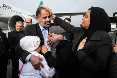 Iranian diplomat Nour Ahmad Nikbakht, abducted in Yemen in 2013, is embraced by his daughters at Mehrabad airport on his return to Tehran after being freed by Iranian special forces.  Amir Pourmand / ISNA / AP Photo