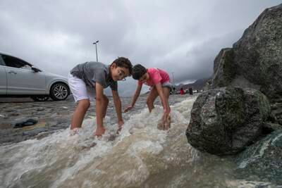 Families stop at the side of a mountain in Khor Fakkan to play in the water. Ruel Pableo for The National