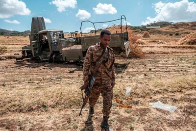 TOPSHOT - A member of the Ethiopian Defense Forces walks away from a damaged military truck abandoned on a road near the village of Ayasu Gebriel, East of the Ethiopian city of Alamata, on December 10, 2020. / AFP / EDUARDO SOTERAS
