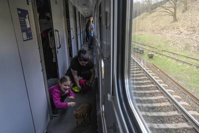Ariana plays with her dogs Chim and Nunia, inside a train, minutes before arriving with her family in western city of Lviv from Kyiv. AP