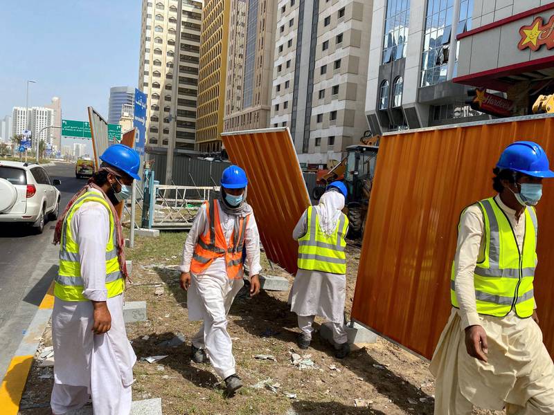 Workers board up a building on Airport Road in Abu Dhabi on Tuesday, September 1, a day after the deadly gas blast. The National