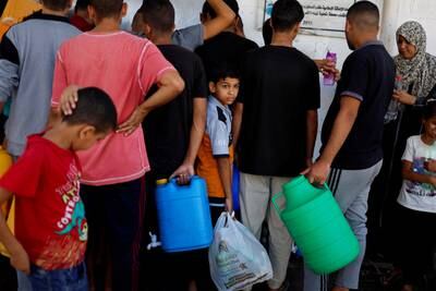 Palestinians collect water as the Israeli-Gaza conflict continues, in Khan Younis in the southern Gaza Strip. Reuters