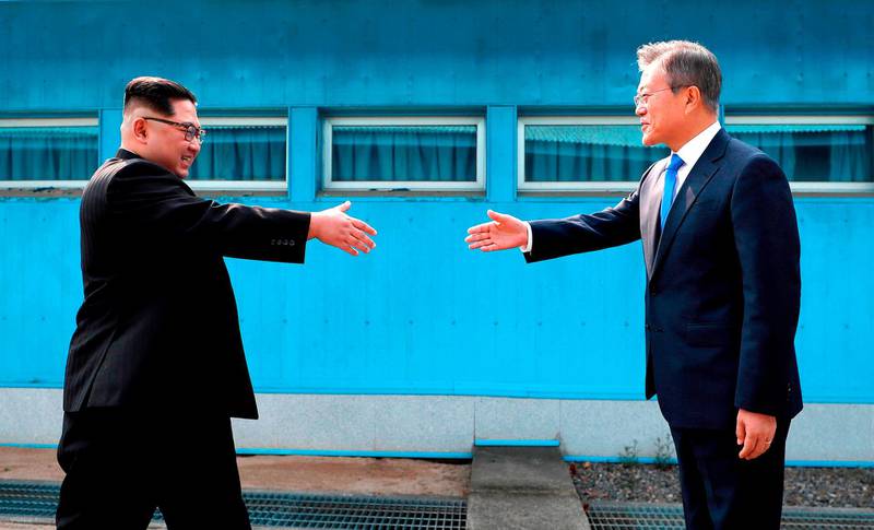 FILE - In this April 27, 2018, file photo, North Korean leader Kim Jong Un, left, prepares to shake hands with South Korean President Moon Jae-in over the military demarcation line at the border village of Panmunjom in Demilitarized Zone. (Korea Summit Press Pool via AP, File)