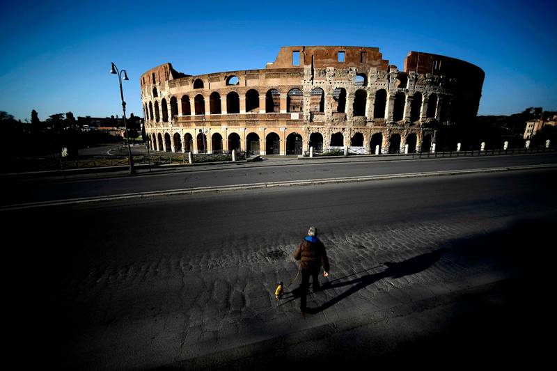 A man walks his dog in front of the Colosseum in central Rome. AFP