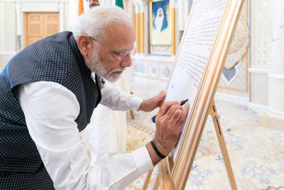ABU DHABI, UNITED ARAB EMIRATES - August 24, 2019: HE Narendra Modi, Prime Minister of India, signs a board announcing the introduction of a postage stamp celebrating 150 years since the birth of Mahatma Gandhi, during a reception at Qasr Al Watan.

( Rashed Al Mansoori / Ministry of Presidential Affairs )
---