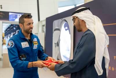 Sheikh Mohamed receives the UAE flag that travelled to the International Space Station with Dr Al Neyadi. Photo: UAE Presidential Court