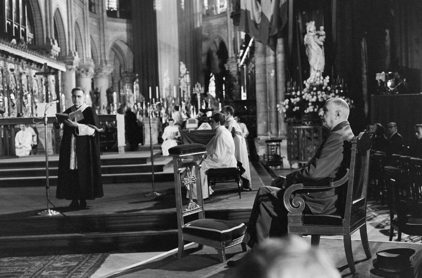 (FILES) In this file photo taken on April 25, 1965 French President Charles de Gaulle attends a mass at the Notre Dame de Paris Cathedral in Paris in memory of deportees who died in concentration camps.   A huge fire swept through the roof of the famed Notre-Dame Cathedral in central Paris on April 15, 2019, sending flames and huge clouds of grey smoke billowing into the sky. The flames and smoke plumed from the spire and roof of the gothic cathedral, visited by millions of people a year.  / AFP / -
