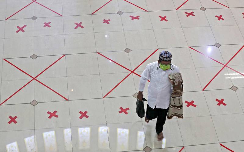 A man walks across marks used to space worshippers apart after Friday prayer at the Al Barkah Grand Mosque in Bekasi on the outskirts of Jakarta, Indonesia. AP Photo