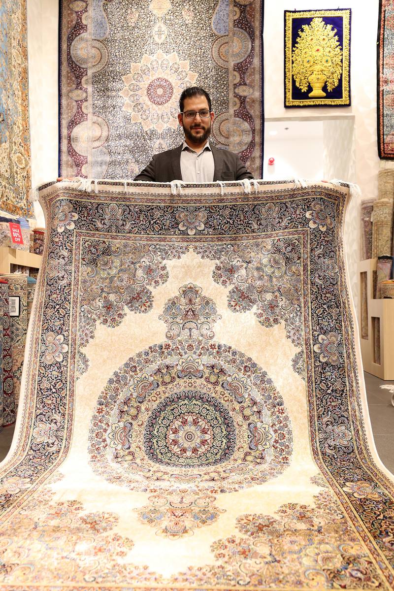 Irfan Jan, a sales executive at Kani Home, with a Persian carpet.