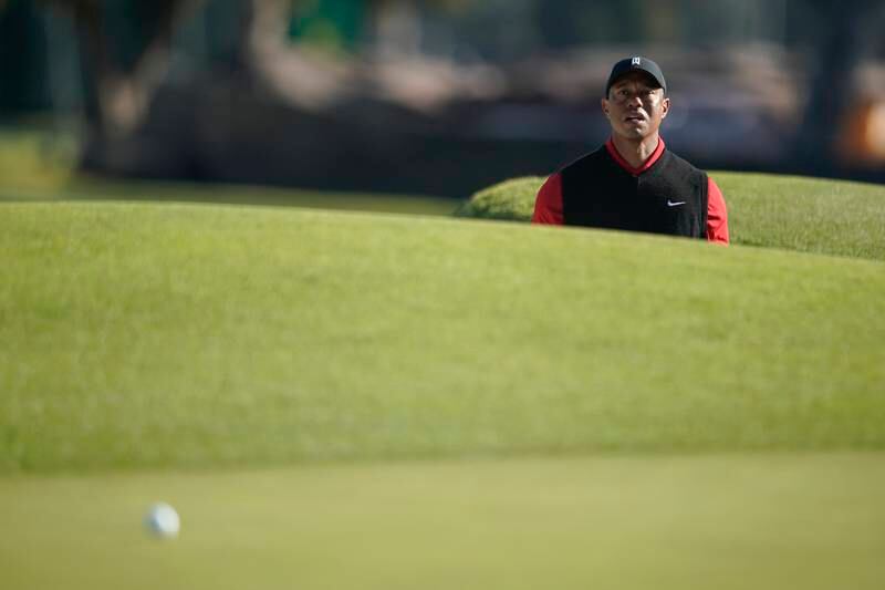 Tiger Woods watches his shot after hitting out of a bunker on the third hole. EPA