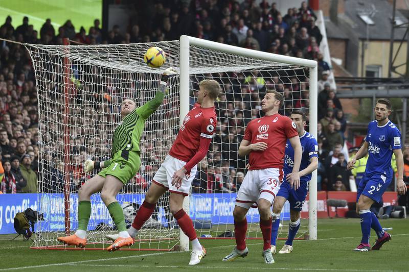 Everton's goalkeeper Jordan Pickford, punches the ball clear under pressure from Nottingham Forest's Joe Worrall. AP 
