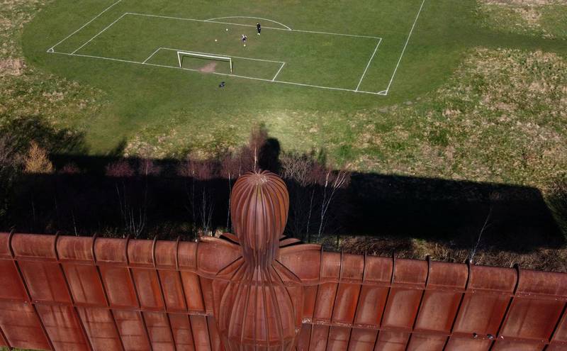 People play football on a pitch next to Antony Gormley’s Angel of the North in Gateshead, Britain. Reuters