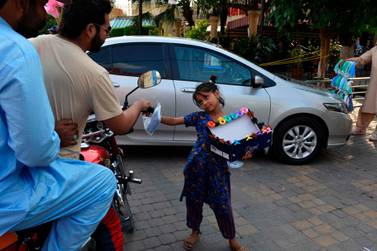 A girl sells a facemask to costumers at Pindi Food Street in Rawalpindi, June 2. Farooq Naeem/ AFP