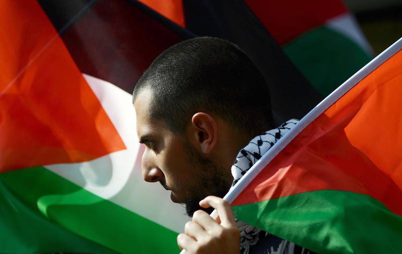 A demonstrator holds a Palestinian flag during a protest in support of the Palestinian cause, on May 12, 2018 in Rome to mark the 70 years since the Palestinian "Nakba" of 1948. The demonstration is also in solidarity with the "Great Return March" protests in Gaza and to protest against the impending move of the US Embassy in Israel from Tel Aviv to Jerusalem.  / AFP / FILIPPO MONTEFORTE

