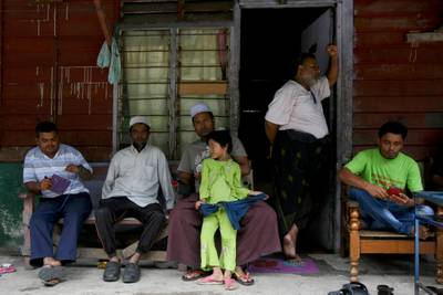 Rohingya Muslims living in Malaysia rest outside a house in Klang, on the outskirts of Kuala Lumpur. Daniel Chan / AP Photo