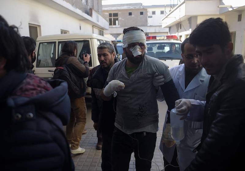 An injured Afghan man is led from an ambulance to hospital. Shah Marai / AFP Photo
