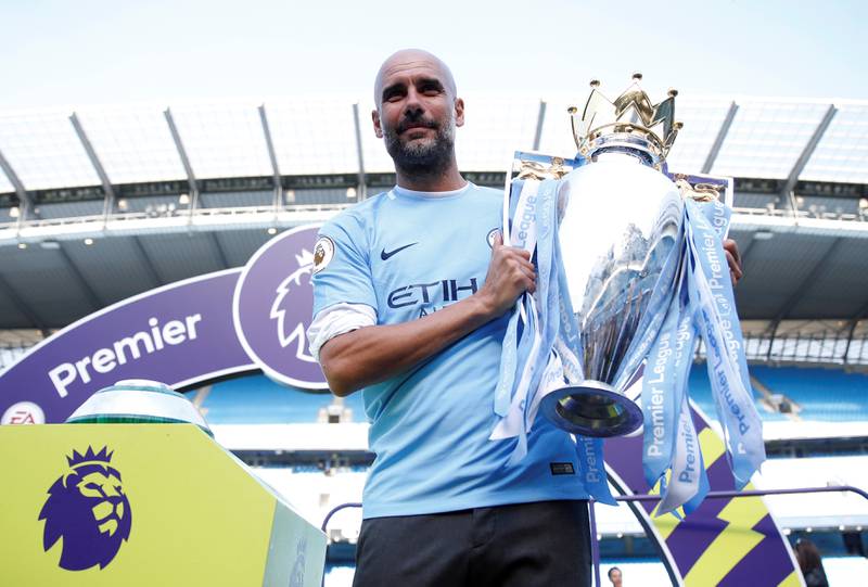 Manchester City manager Pep Guardiola celebrates with the trophy after winning the Premier League at Etihad Stadium on May 6, 2018. Reuters