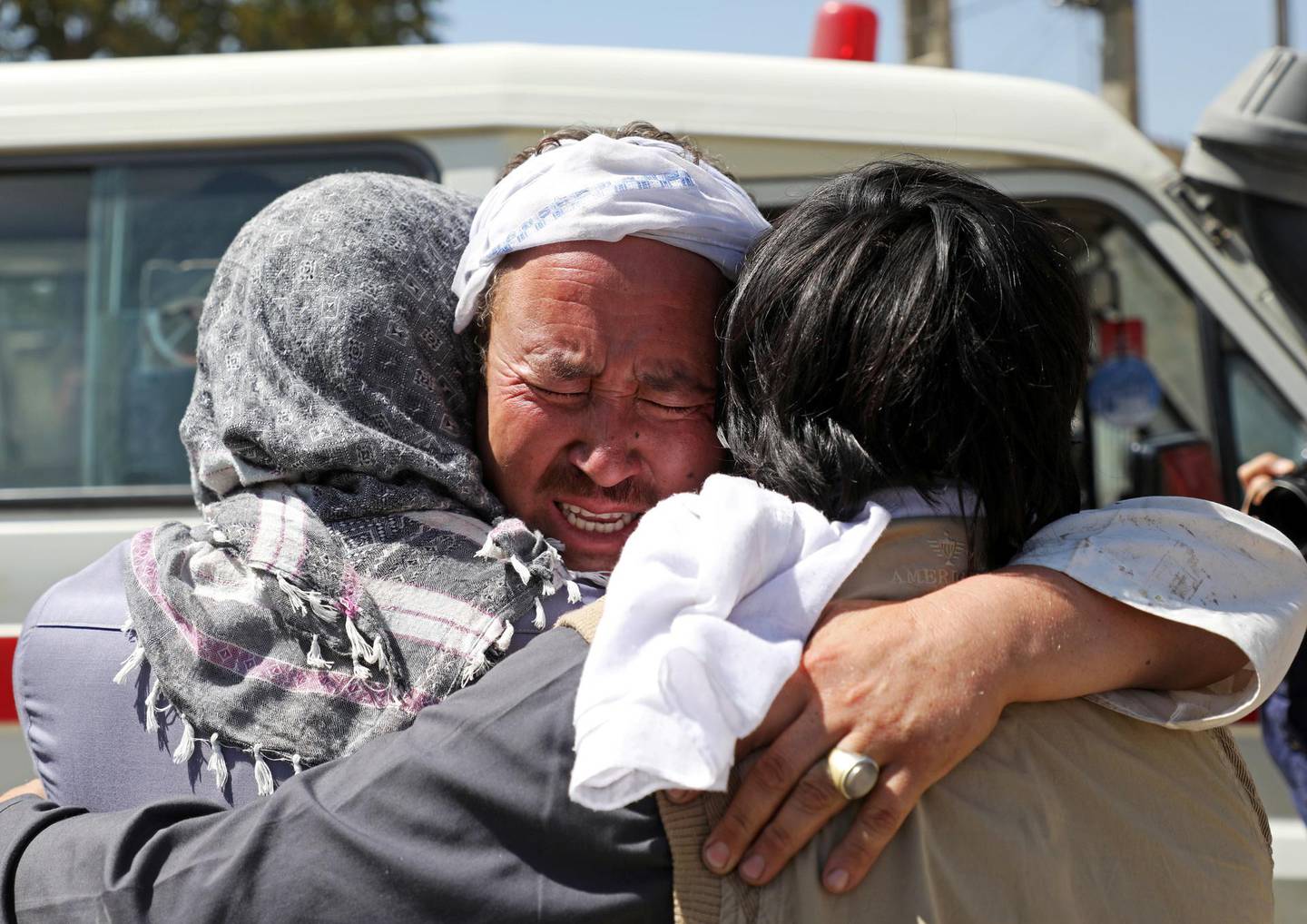Afghan men hug each other as they mourn during the funeral of their relatives after a wedding suicide bomb blast in Kabul, Afghanistan August 18, 2019. REUTERS/Omar Sobhani