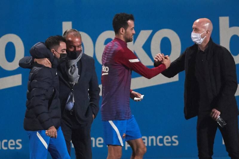 Barcelona's head coach Xavi hugs Rafa Yuste as player Sergio Busquets shakes hands with Jordi Cruyff. EPA