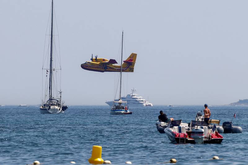 An aircraft flies off after being filled with water to help with efforts in extinguishing a major fire that broke out in the Var region, at the Gulf of Saint-Tropez.