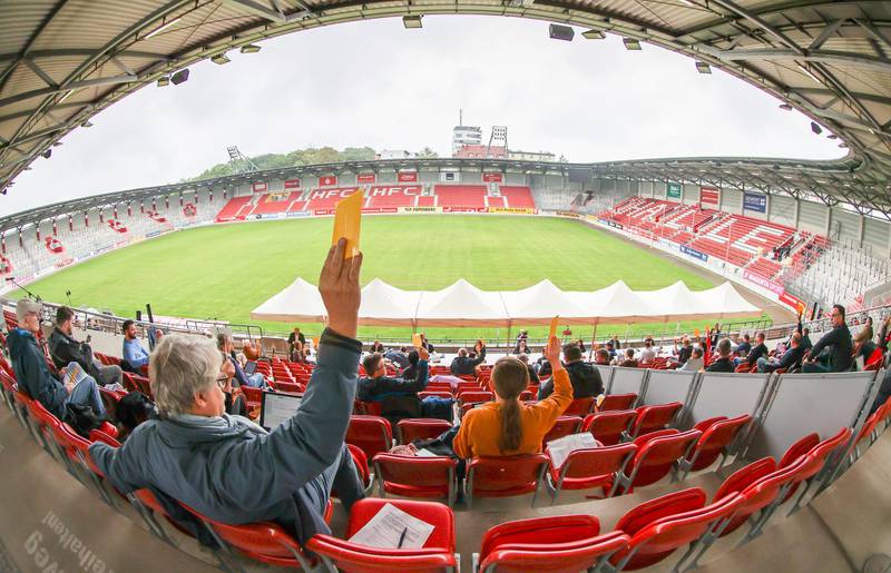 To maintain social distancing, members of Halle's city council vote outdoors during a meeting in the stands of the stadium of Hallescher FC in Germany. Long debates can also be continued outside under floodlights. DPA via AP
