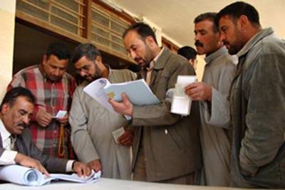 Sunni Muslim men have their papers checked at a polling station as they wait to vote in provincial elections in Fallujah, on Jan 31 2009.