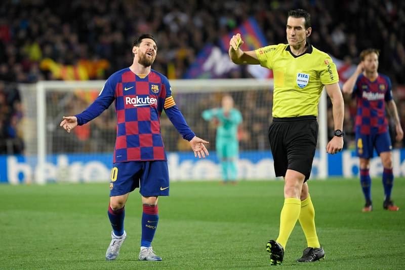 Spanish referee Juan Martinez shows a yellow card to Lionel Messi against Real Sociedad at the Camp Nou. AFP