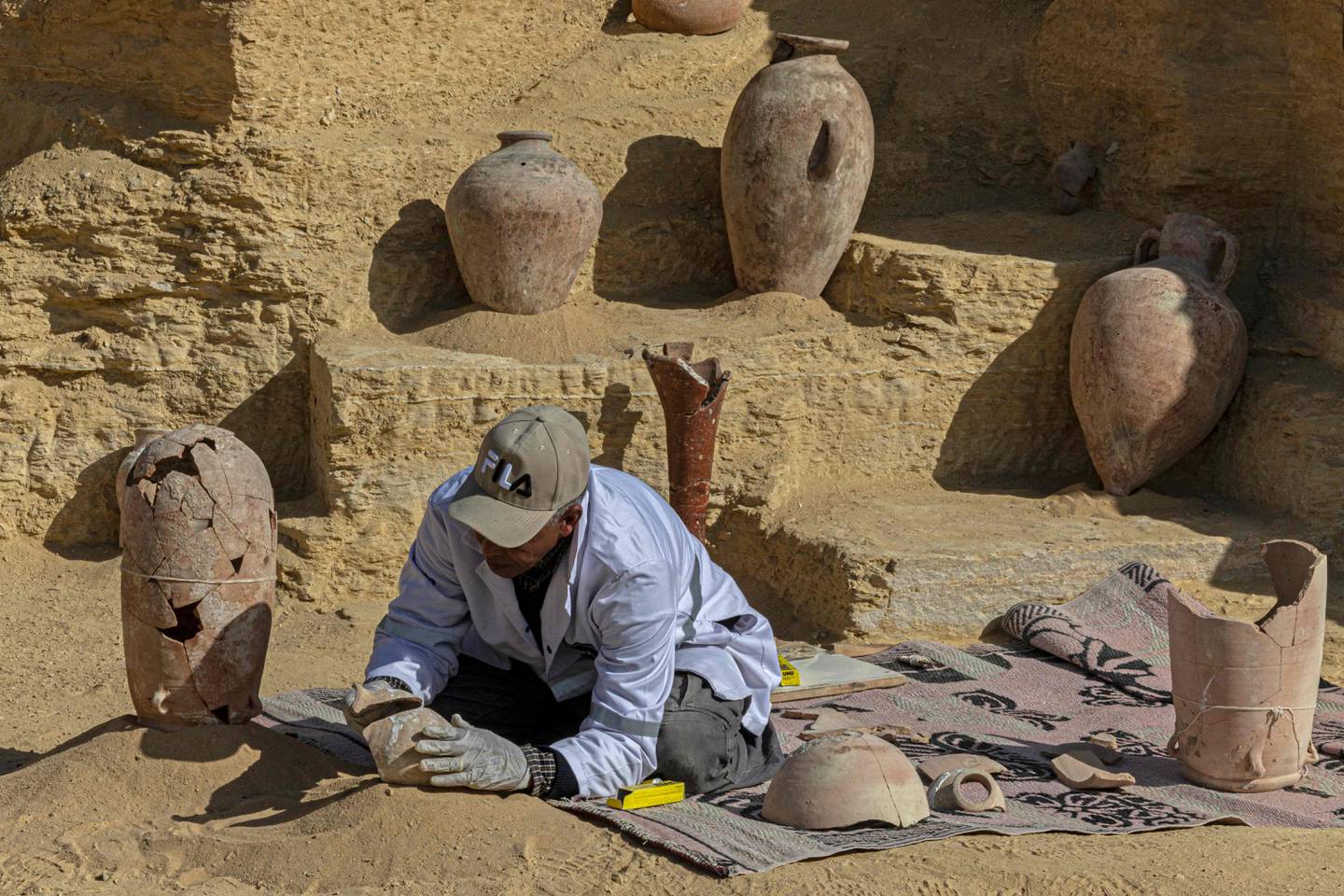 Un archéologue égyptien reconstitue des antiquités découvertes sur le site de Saqqarah.  AFP