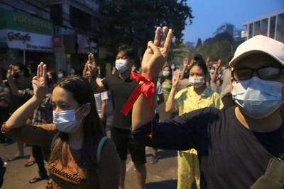 Anti-coup protesters flash three-fingered gesture, a symbol of resistance, during a rally outside their homes in downtown Yangon, Myanmar. AP Photo