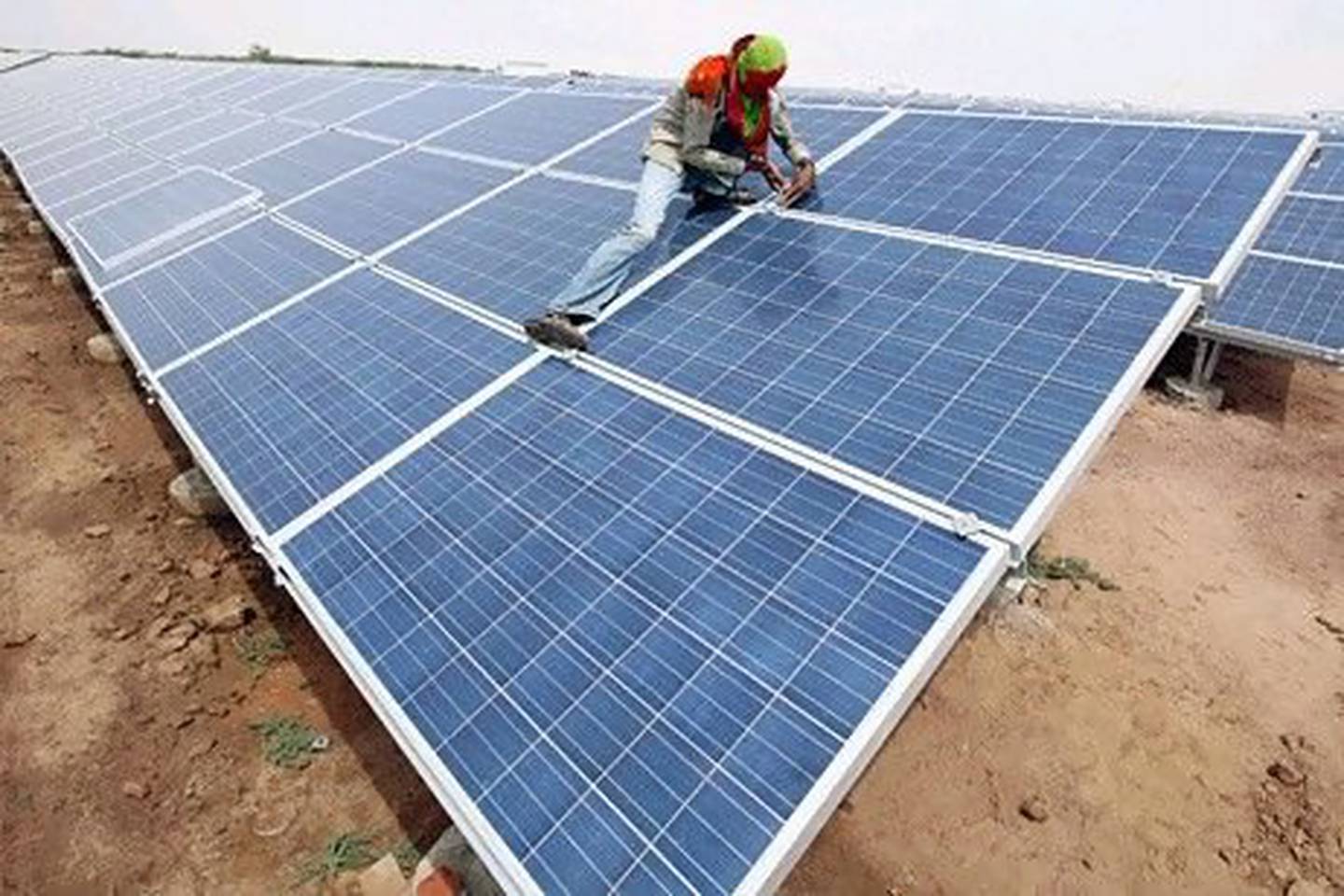 Saudi Arabia's plans to produce a third of its electricity from solar power may revitalise the industry. Above, a worker installs photovoltaic solar panels at the Gujarat solar park in India. Reuters
