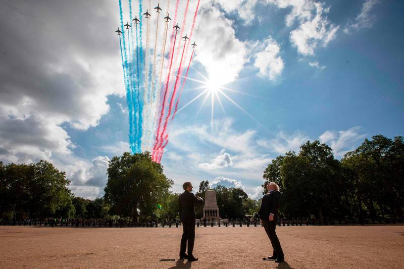 French President Emmanuel Macron, left, and Britain's Prime Minister Boris Johnson watch as The Royal Air Force Aerobatic Team, the Red Arrows, and the French Air Force Aerobatic Team, La Patrouille de France, perform a fly-past from Horse Guards Parade in London during a visit to commemorate the 80th anniversary of former French president Charles de Gaulle's appeal to French people to resist the Nazi occupation during World War II. AFP